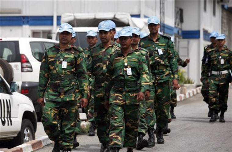 UN troops walk inside the UN Headquarters in Abidjan, Ivory Cost on Friday. The United Nations is warning supporters of incumbent leader Laurent Gbagbo that an attack on the hotel where the internationally recognized winner of last month's election is based could re-ignite civil war. 